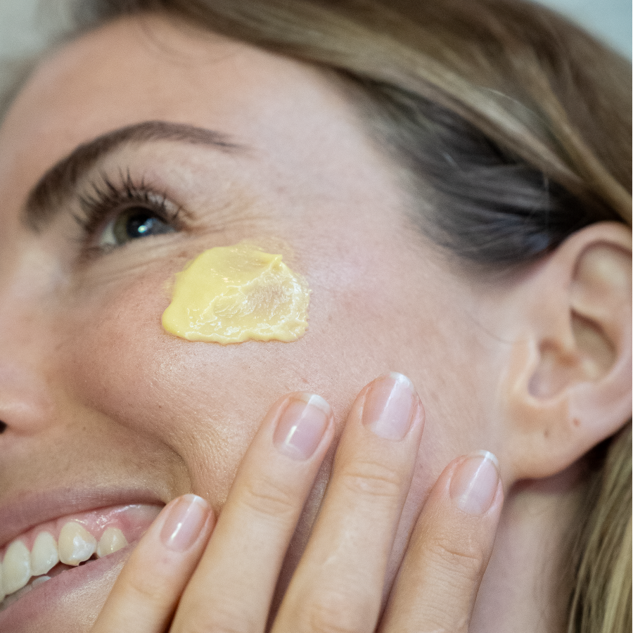 applying orange serum to face yinera skincare